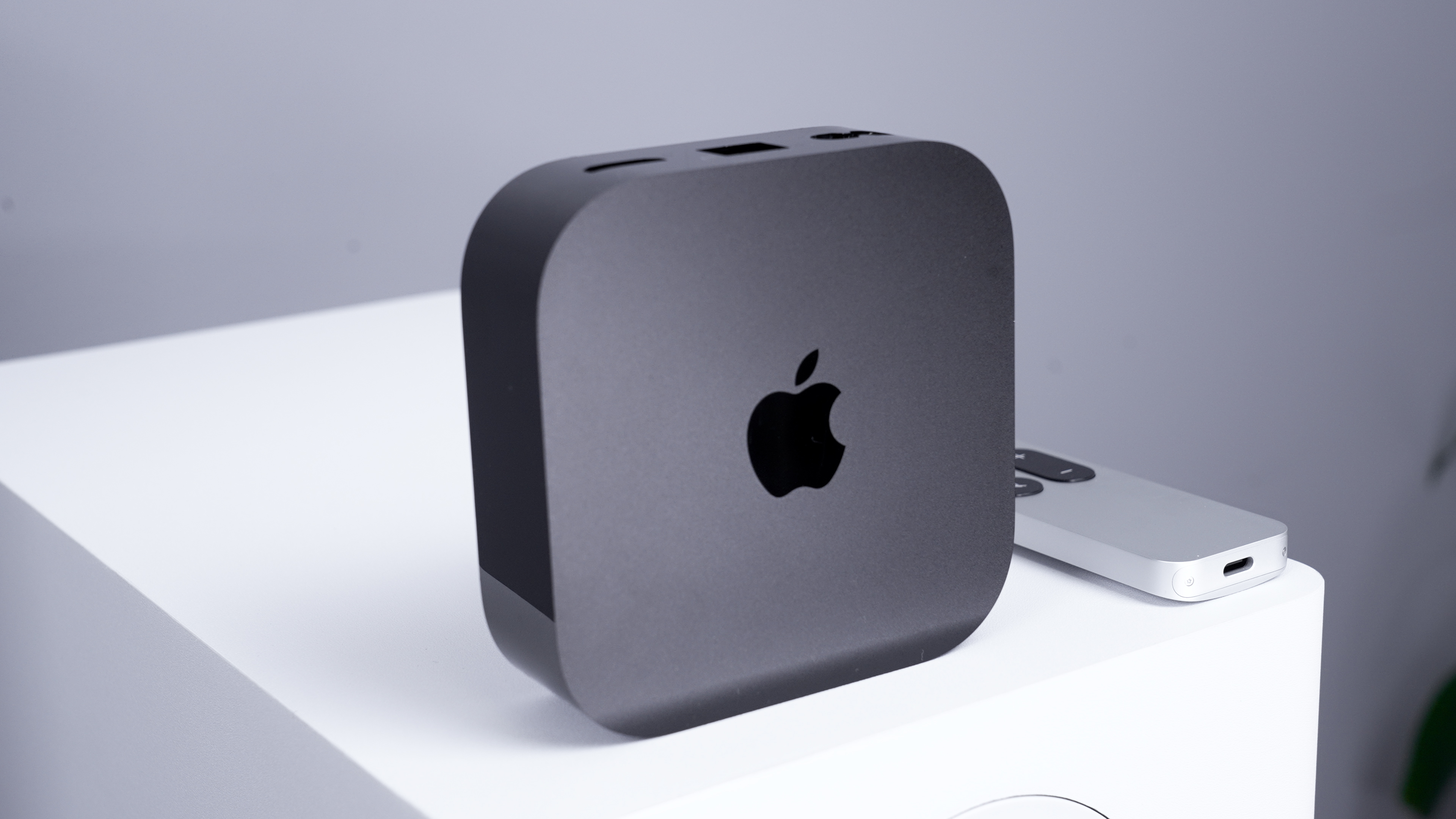 The Apple TV 4K standing vertically with the Apple logo showing from the front