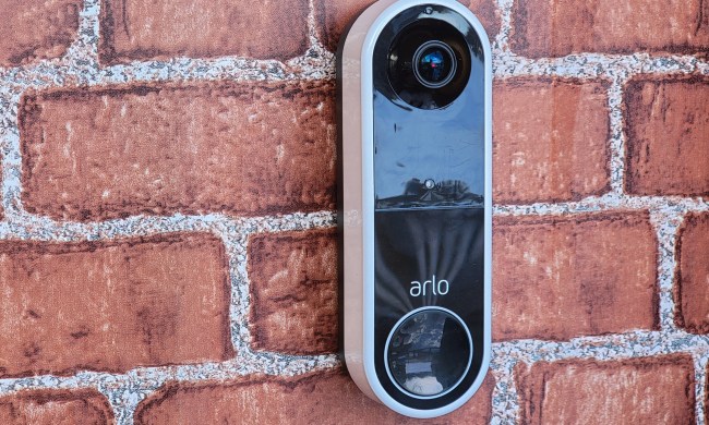 Arlo Essential Wireless Doorbell mounted on brick wall.