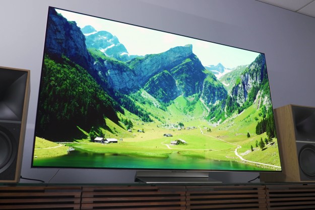 The LG G3 OLED TV on a stand, showing a mountain scene on the screen.